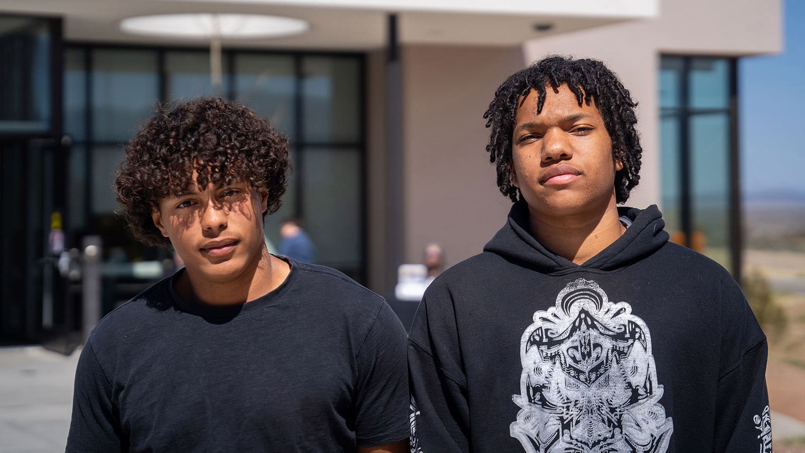 two male students in front of a UNM-Taos builiding